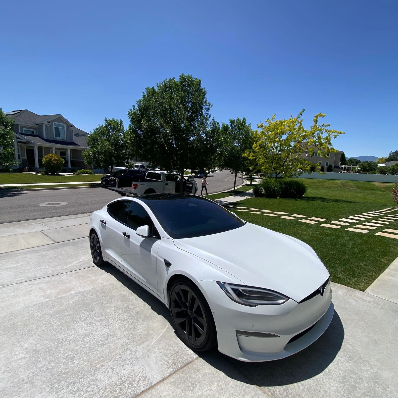 White Tesla detailed in a suburban driveway, one of Jack's own jobs