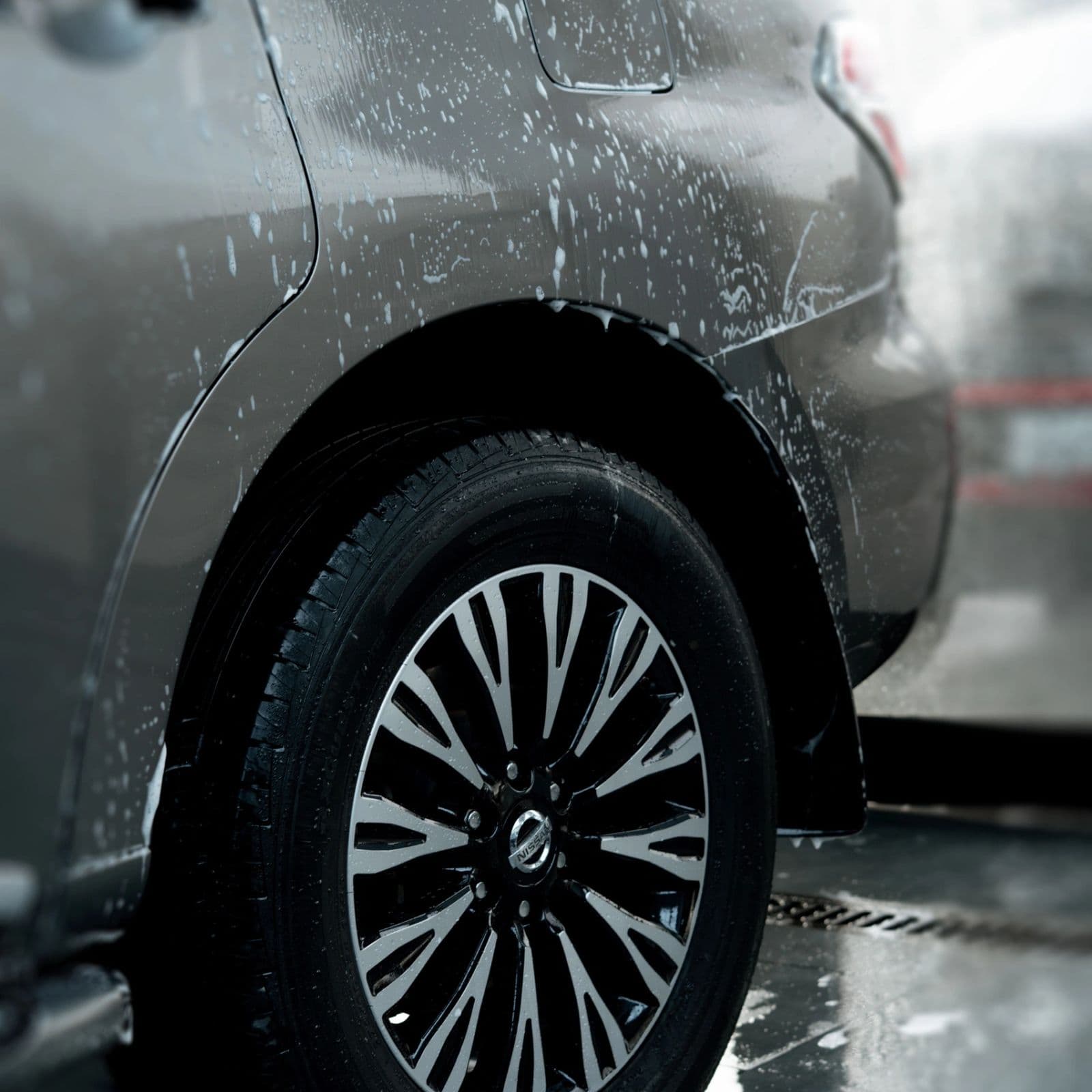 Freshly washed wheel and wet bodywork on a dark car