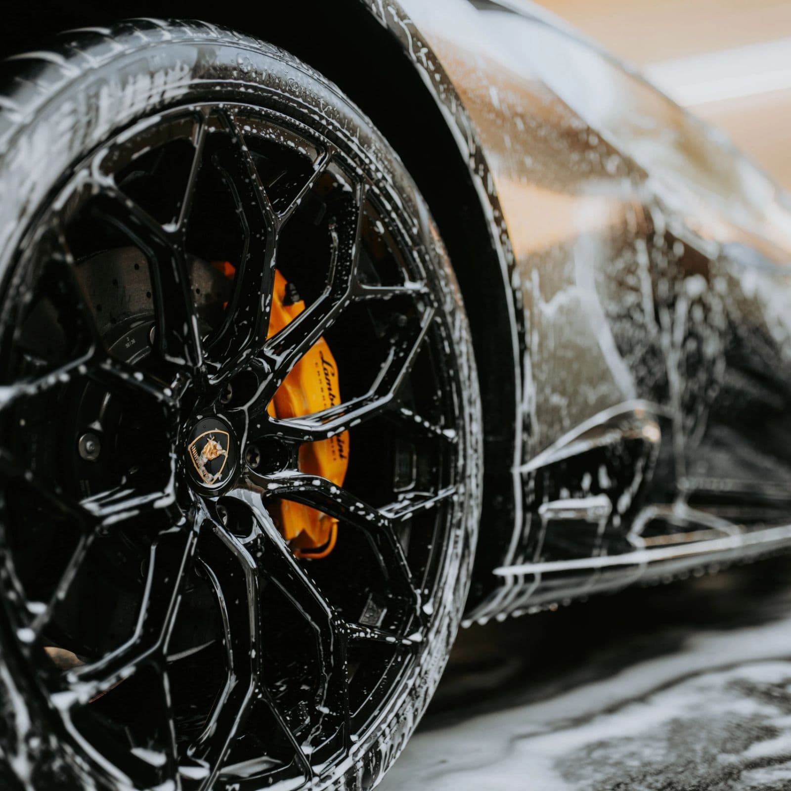 Wheel covered in wash foam during a hand wash