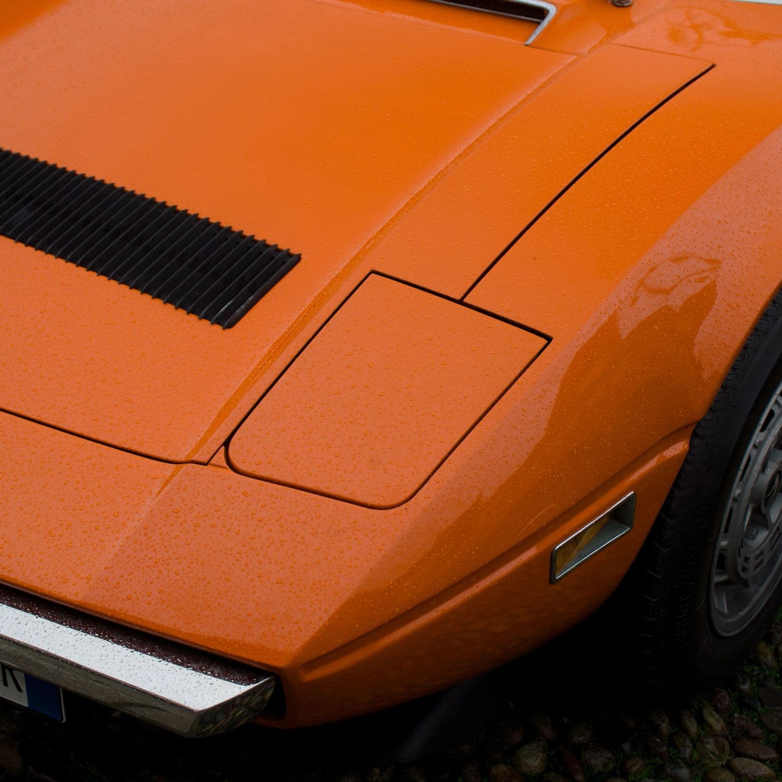 Deep orange body panel and hood vent on a wrapped car